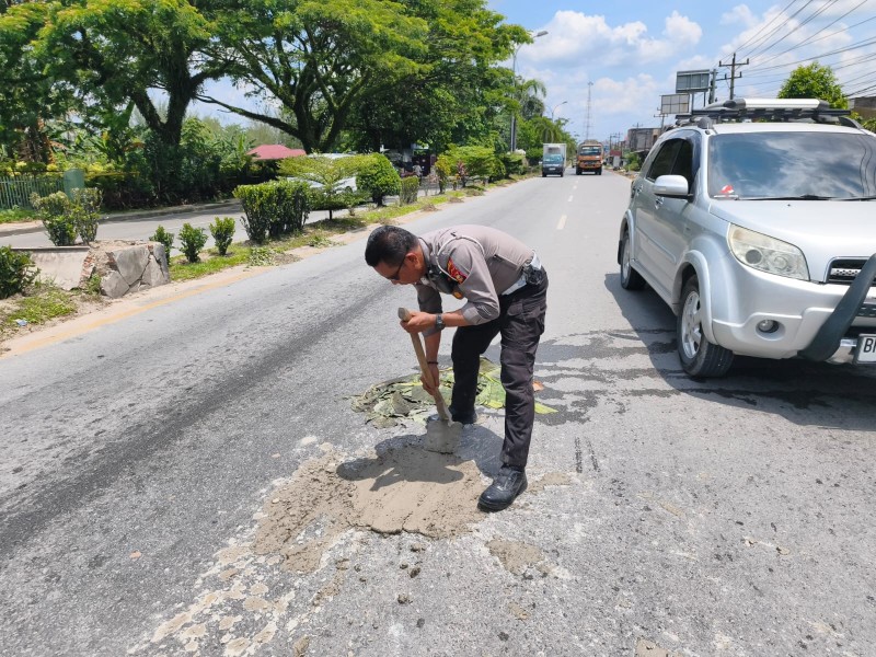 Personel Satlantas Bergerak Tutup Jalan Berlubang
