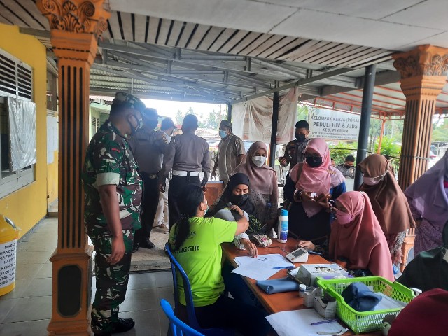 Babinsa Serda Ahmad Junaidi Tinjau Pelaksanaan Vaksinasi di UPT Puskesmas Pinggir KM 3 Sebanga
